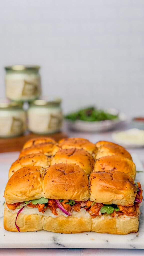 chicken sliders head on image. filled with purple cabbage, arugula, onions