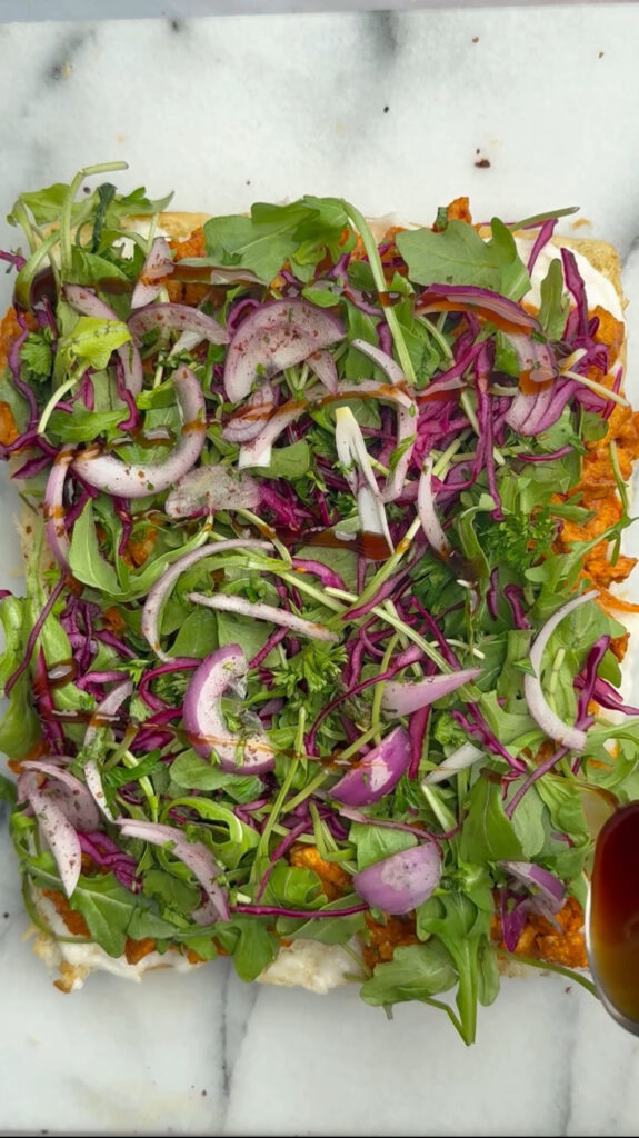 arugula, purple cabbage, red onions layered over chicken 
