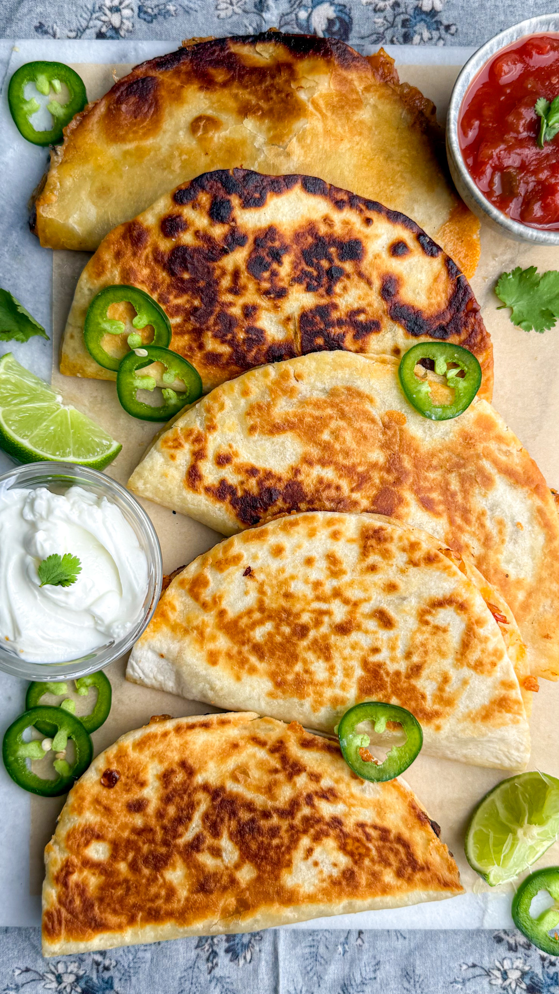 quesadillas laid flat topped with jalapeños and limes