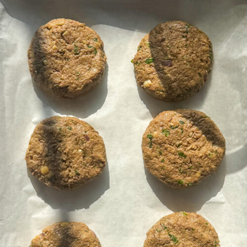 6 beef shami kebab patties on a tray. uncooked.