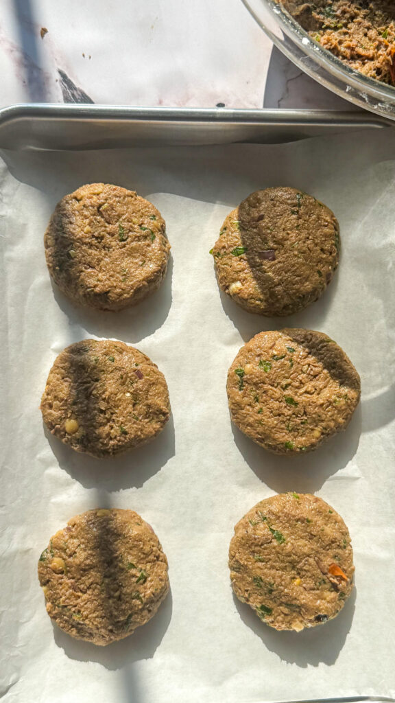 6 beef shami kebab patties on a tray. uncooked.